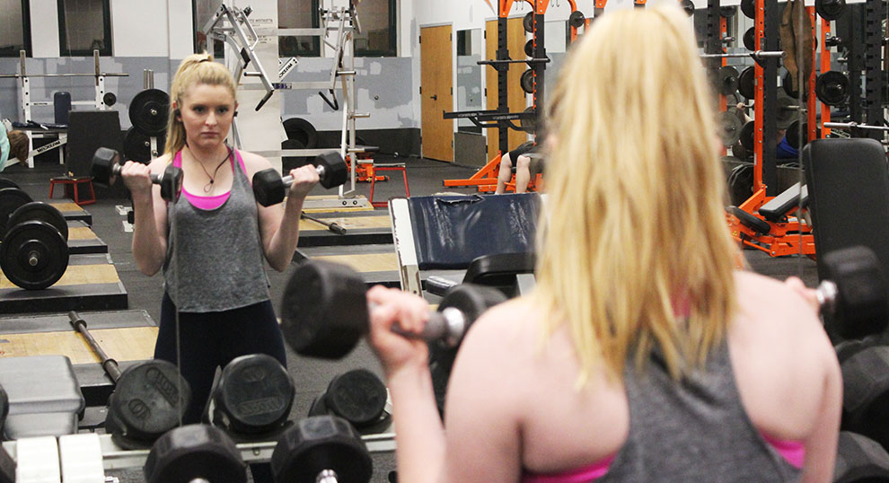 Senior Erin Thompson pumps some iron on Jan. 30 in the Mabee gym. If the new community center is built, non-athletes like Thompson will have an alternative place to work out. Image by Shelby Stephens.