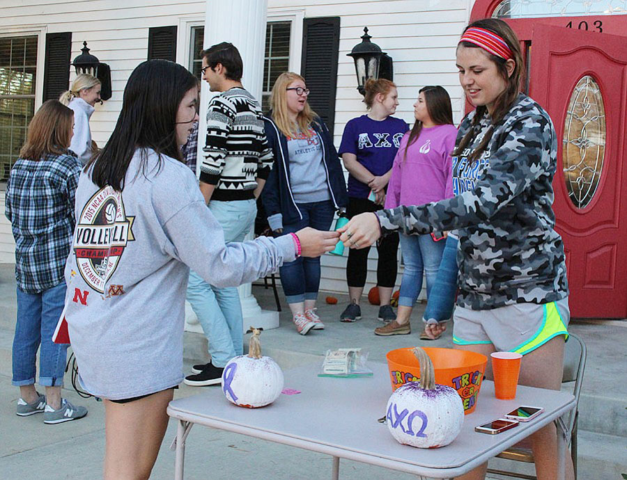 Sophomore Maddy McGlade collects tickets at Alpha Chi Omega's domestic violence awareness event 