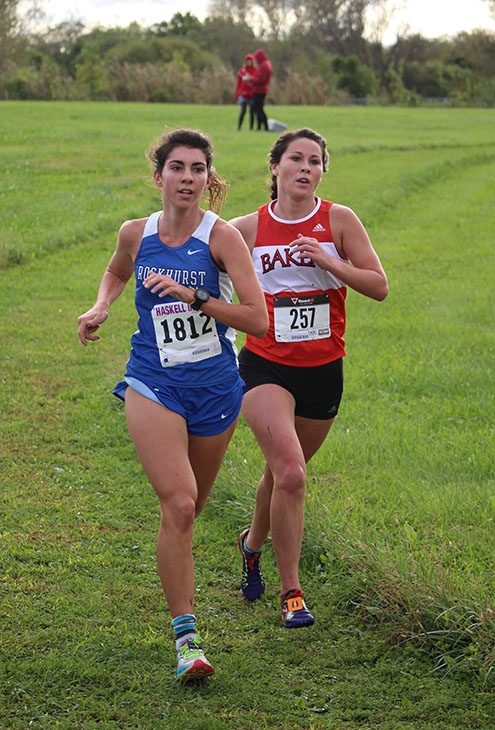 Senior Rosie Hollis runs alongside a runner from Rockhurst University. The women ran a 5 kilometer (3.1 miles) race. Their run was less muddy than the mens, but several runners still slipped and fell during the competition. Hollis finished as the top runner for the Baker womens team, earning 15th place overall. 