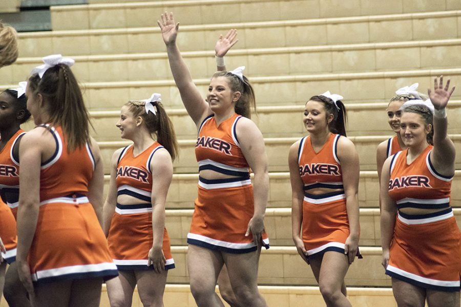 Senior Kira Eddy waves to the crowd alongside her teammates on Jan. 28. The cheer team finished in eighth place with 50.23 points.
