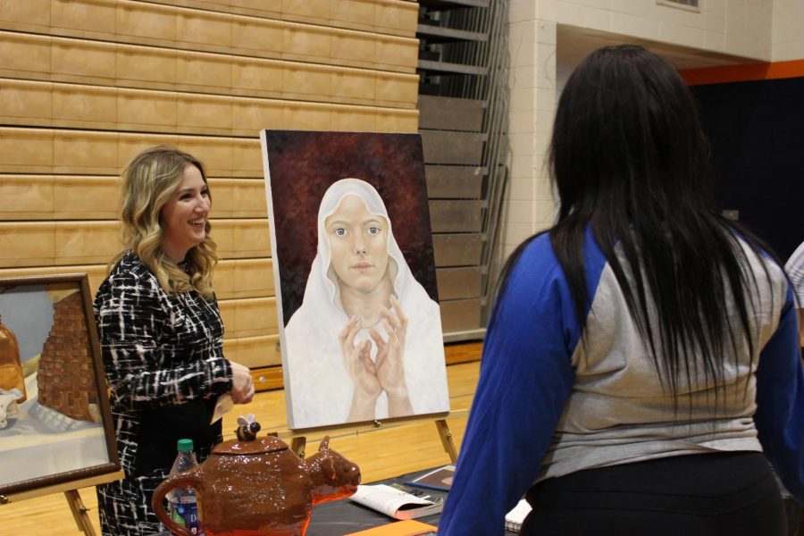 Sophomore Erynne Jamison presents her artwork to Junior Aradaisia Walker at Dialogos on April 18. Dialogos takes place in Collins Center every year where students present and are awarded scholarships. There is no class the day of Dialogos to allow students to attend this event during the day.