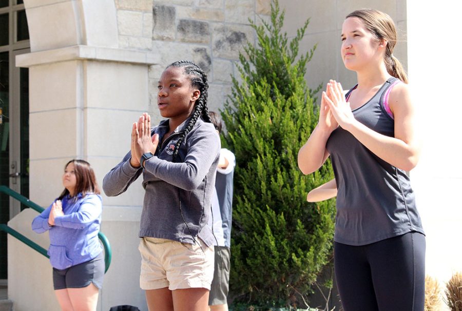 Sophomores Kayla Carter (left) and McKenzie Becker (right) do breathing exercises to relax at the opening of Power Yoga.