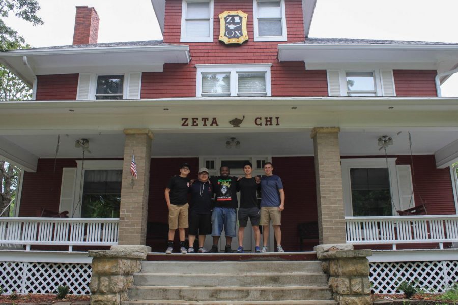 Members of  the Zeta Chi fraternity stand proudly on the front porch of their house located on 8th Street. 