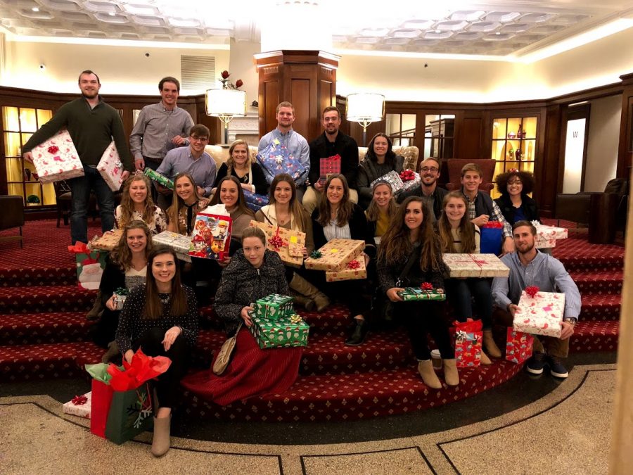 The parMentors pose with gifts purchased for the “Adopt-a-Family” project. The items were wrapped at the Eldridge Hotel following the group dinner.