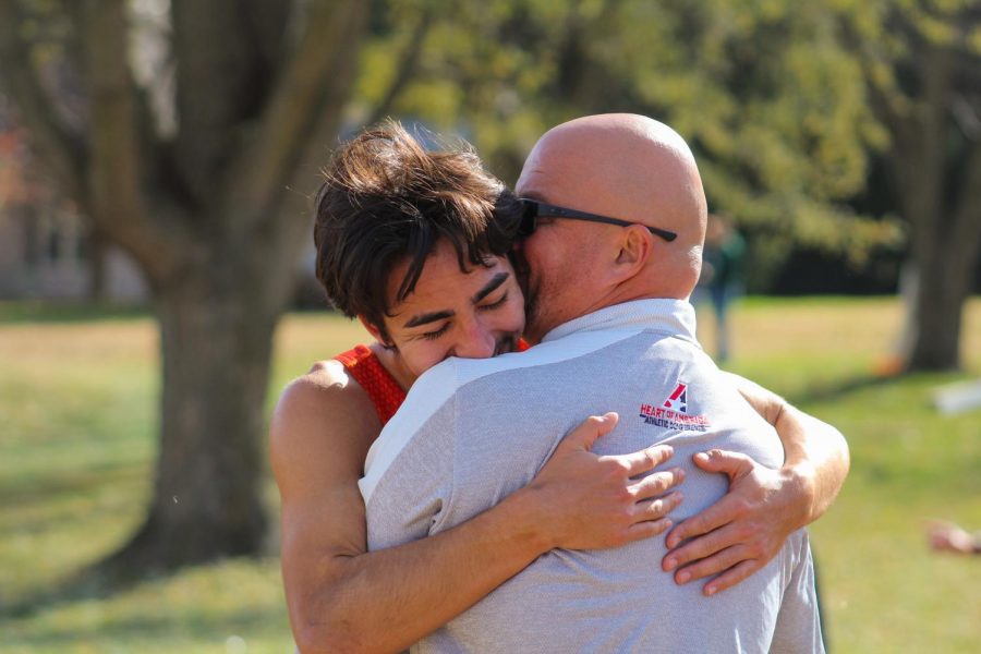 Senior Adam Preston embraces coach Tim Byers after his 12th place finish. Preston left it all on the course and finished fourth on the team, earning him a spot on the mens national squad of seven runners. 