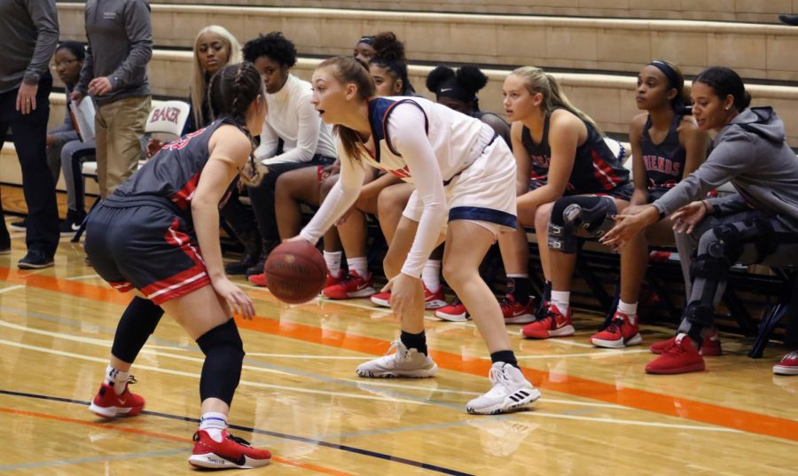 Freshman Leah Vanweelden dribbles in front of the Friends University bench in the first home match of the season. Vanweelden scores a career high of 15 points against the Falcons.