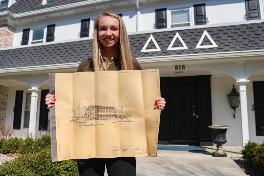 Junior Kaylee Smith, current president of the Baker University Delta Delta Delta sorority, holds up the original blueprints for the house. The blueprints were uncovered recently and are a memorable historical find for the members of the house.