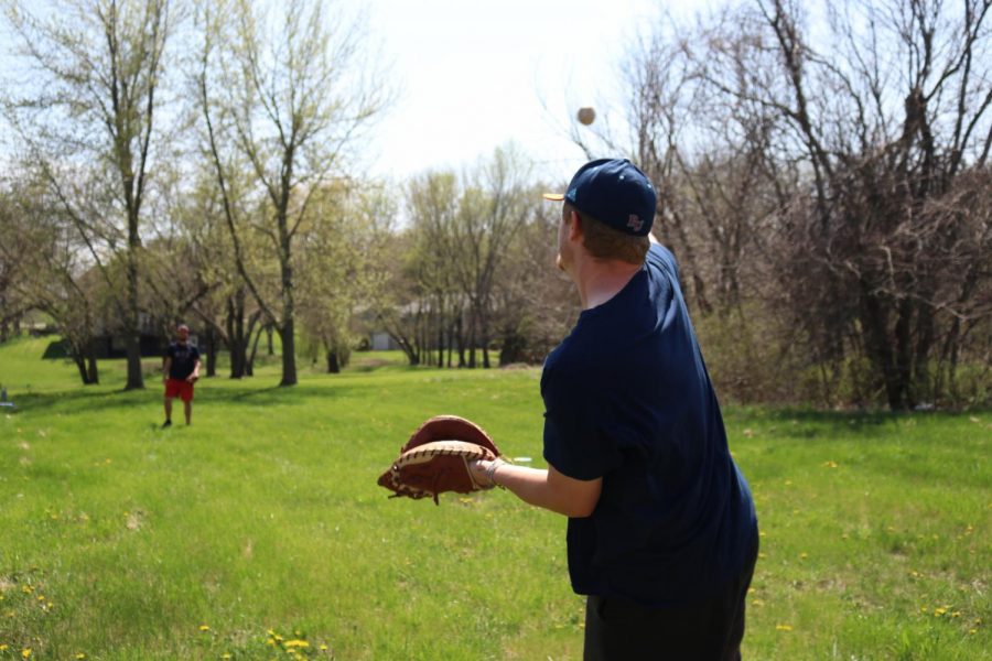 Baker University Baseball players, senior Martin Radosevic (left) and junior Donovan Sutti (right) play catch in their free time despite the impact that COVID-19 has had on their season. 