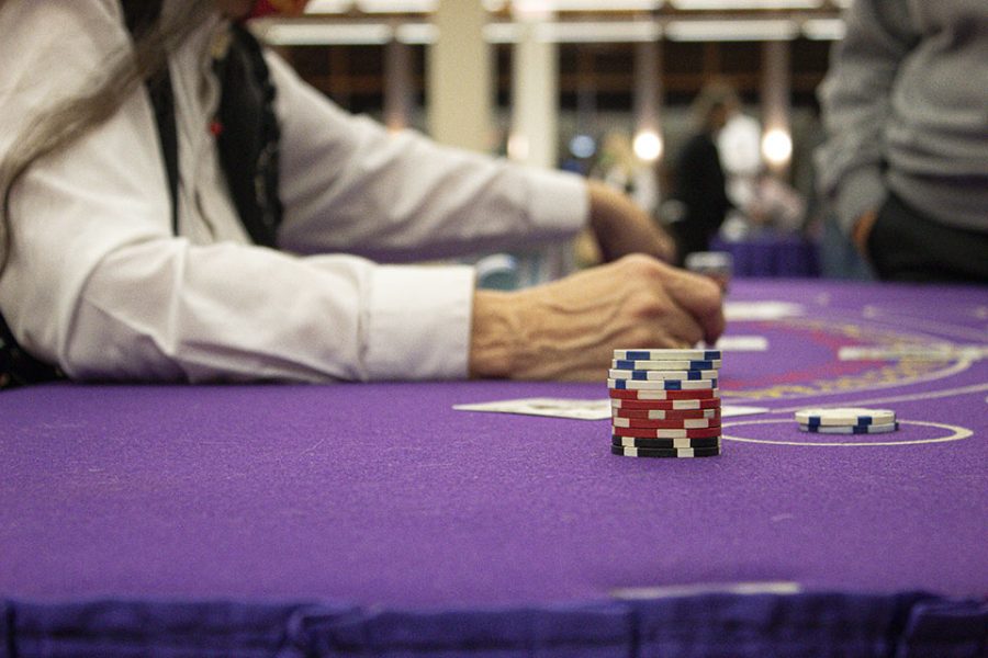 A dealer handles cards while a stack of chips awaits the hands results. 