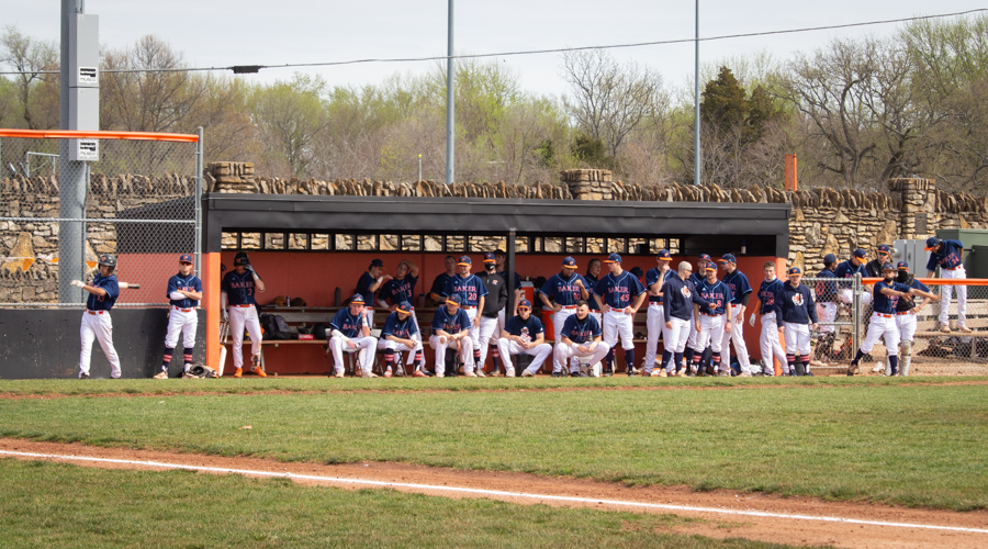The Baker baseball team cheers on their teammates from the dugout as they play against MidAmerica Nazarene University.