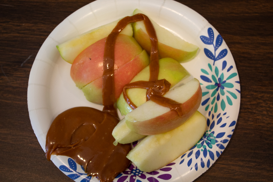 Students had the option to eat cut apples with caramel over the top.
