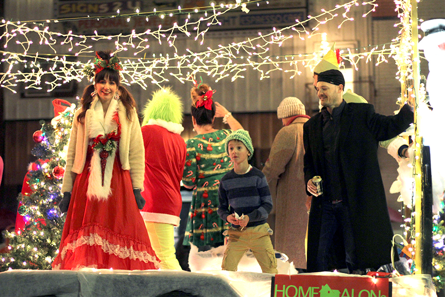 Dressed as characters from Home Alone and The Grinch, parade participants ride on a float and pass out candy to the crowd. 