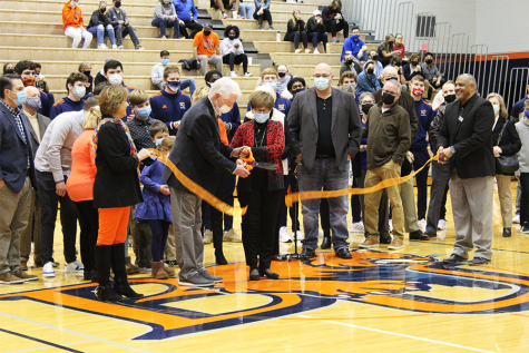 Baker Alumni Greg Goff 71 (left) Helen Elliott (right) cut the ceremonial ribbon that officially declares the Mansfield-Elliott Locker Room complete and ready for use. Elliott is the wife of J. Nelson Elliott, one of the alums to which the locker room is dedicated.