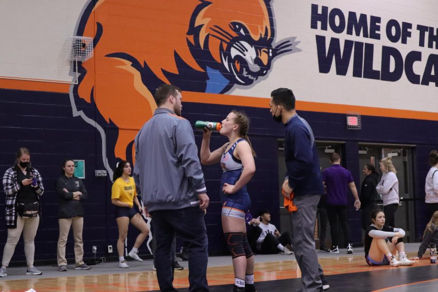 Head coach Cody Garcia gives Sophomore Nichole Moore a pep talk during her match intermission. This year completes his fourth season with Baker Womens wrestling. 
