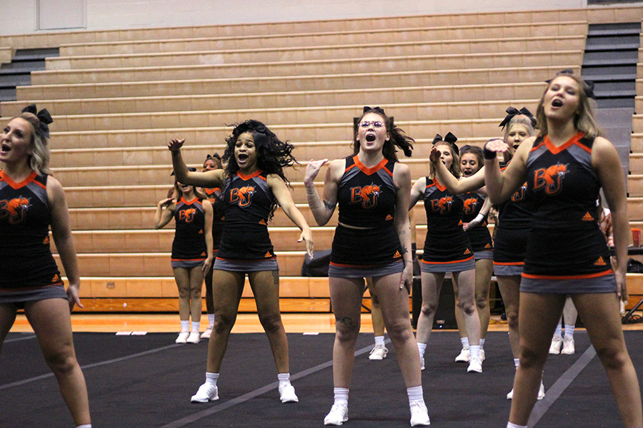 Kicking off their routine, the cheer team engages the crowd in Collins Gym during the Baker Classic.