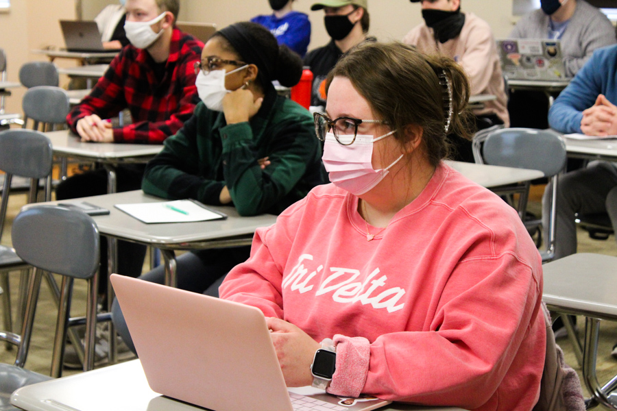 Senior+Hanna+Stevens+wearing+her+mask+amongst+her+classmates.+Masks+are+now+only+required+in+classrooms%2C+unless+a+professor+opts+for+no+masks.