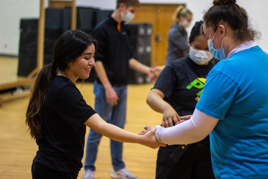 Starra Zweygardt (center), an assistant manager and instructor at Premier Martial Arts, offers technical feedback to Freshmen Patty Salazalz (left) and Dejia Griego (right). The golden rule of Krav Maga is to go home safe. Do what you need to do to get yourself home at the end of the day, Zweygardt explained.