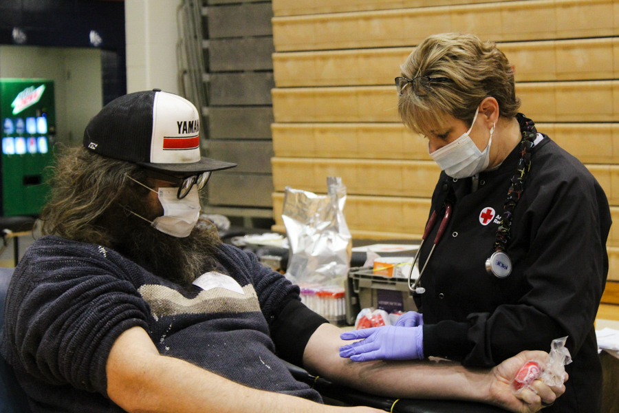 A nurse from the American Red Cross  getting community member Joey Zibell prepped to donate. They discussed what she was doing and what to expect afterwards. 