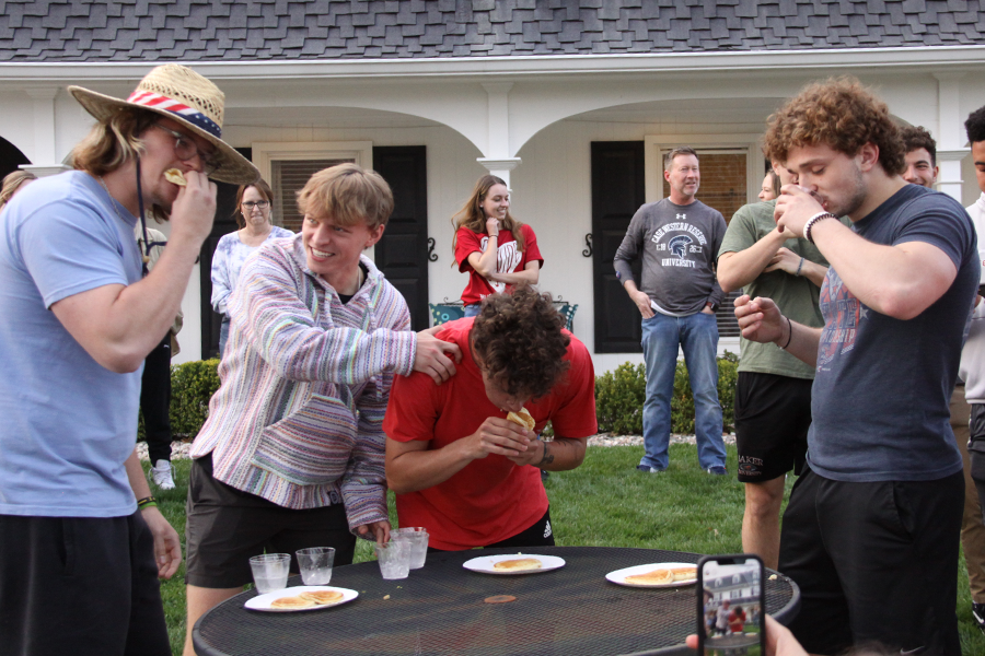 Juniors Ben Banks (left), Lucas DeHaan (center-right) and Sophomore Roman Bushek (right) participate in a pancake eating contest. Bushek came in first place.