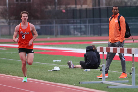 Senior Jacob Cofer runs the 10K at Friends University on April 1 as Coach Ryan Pitts looks on. Cofer finished in second place with a time of 32 minutes and 50 seconds. 
