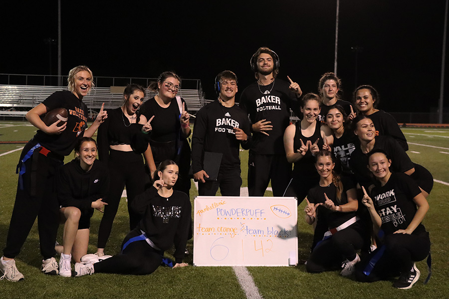 Team black poses with their winning scoreboard after beating team orange 42-6. 
