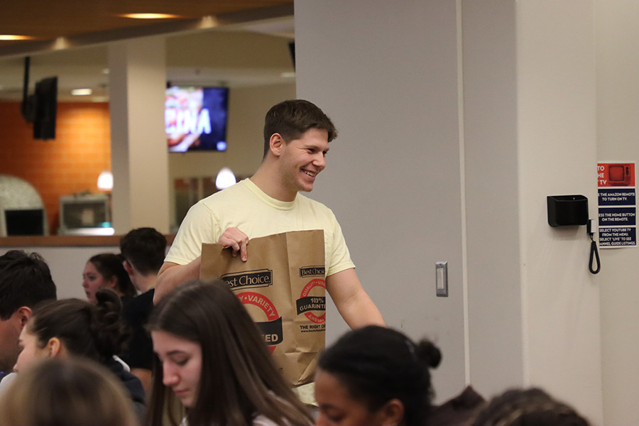 Freshman Kody Howard heads back to his table after winning a card of grocery bingo on Feb. 5. 
