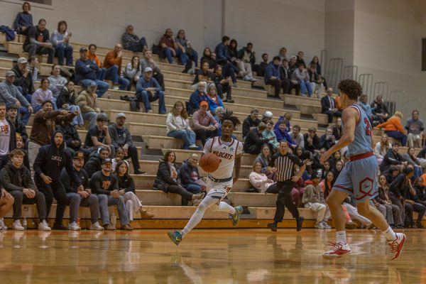 Senior Myles Tucker runs ball up the court against the Pioneers.