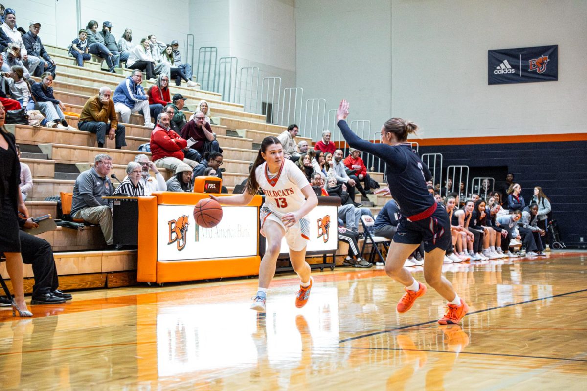 Lauren Berg (#13) drives on a MNU defender