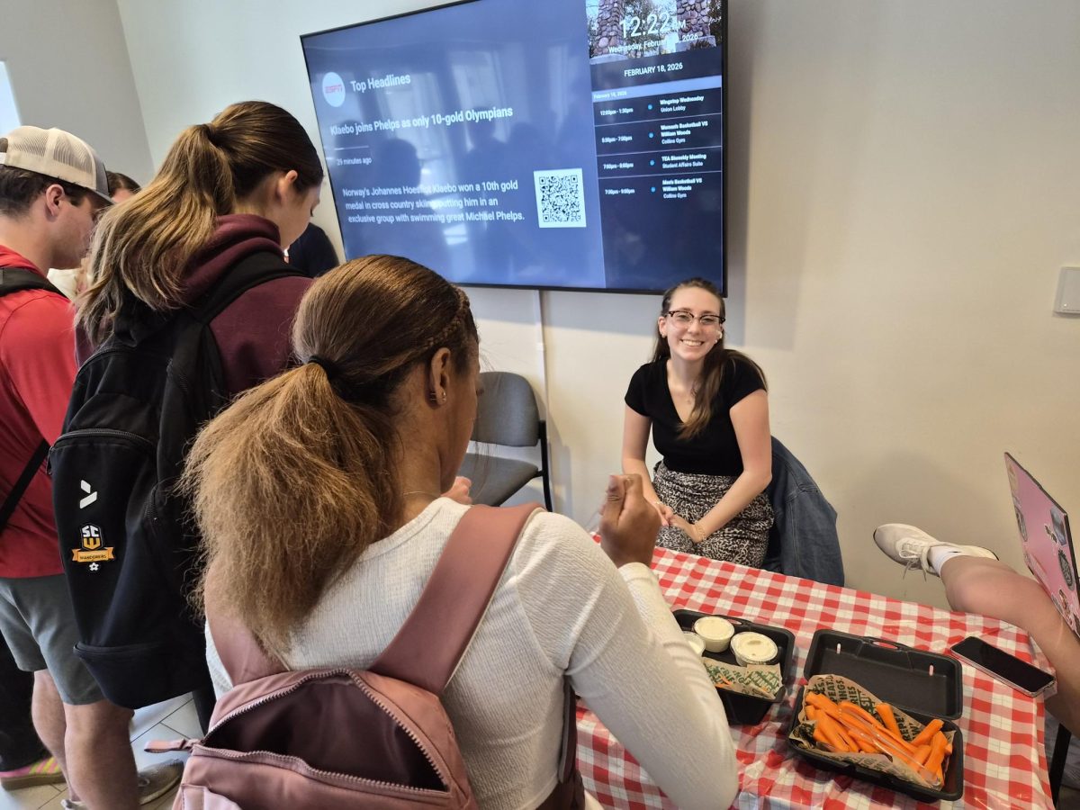 Students line up to get free wings from SAC member Madelyn Christopher.
